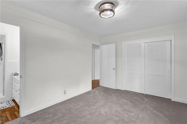 unfurnished bedroom with connected bathroom, a closet, and carpet