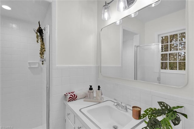 bathroom with vanity, an enclosed shower, and tile walls