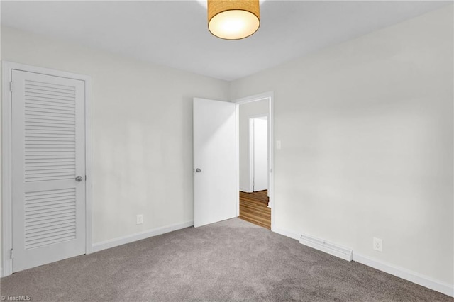 unfurnished bedroom with light colored carpet and a closet