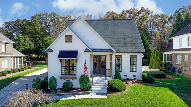 view of front of property featuring cooling unit, a front yard, and french doors