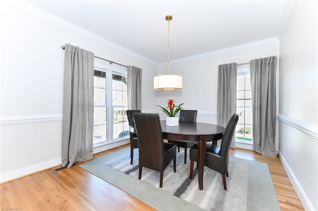 dining area featuring light hardwood / wood-style flooring, a healthy amount of sunlight, and ornamental molding