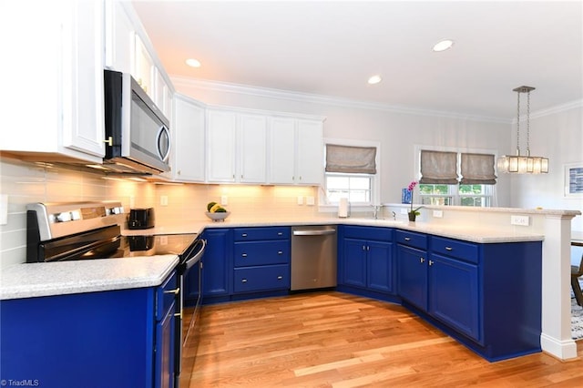 kitchen with white cabinets, appliances with stainless steel finishes, light hardwood / wood-style floors, and decorative light fixtures