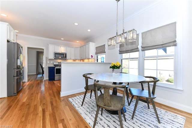 dining room featuring light hardwood / wood-style flooring and ornamental molding