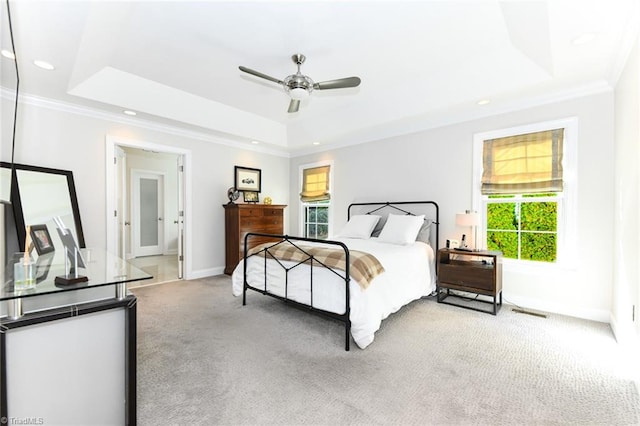 bedroom featuring ceiling fan, a raised ceiling, carpet floors, and crown molding