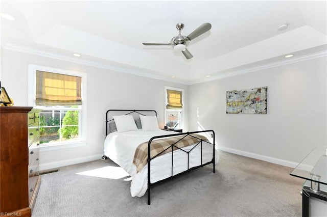 carpeted bedroom featuring a tray ceiling, ceiling fan, and crown molding