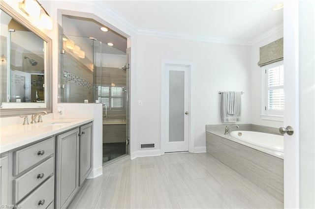 bathroom featuring plus walk in shower, vanity, and ornamental molding