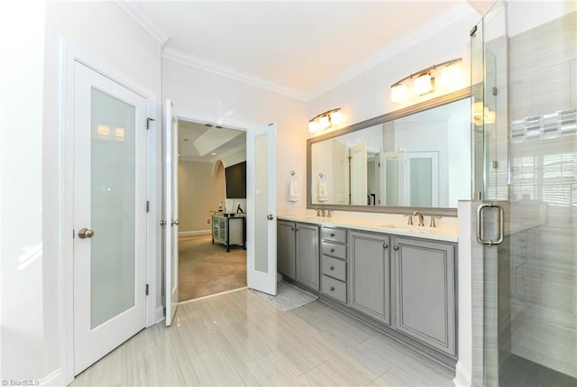 bathroom with vanity, a shower with door, and ornamental molding