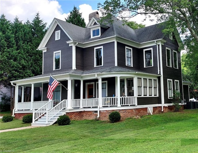 view of front of property with a front lawn, central AC unit, and a porch