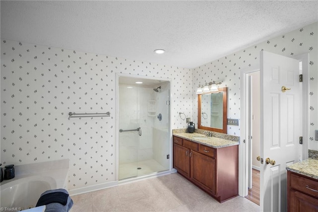 bathroom featuring tile patterned floors, vanity, a shower with door, and a textured ceiling