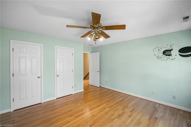 unfurnished bedroom with ceiling fan and light hardwood / wood-style floors