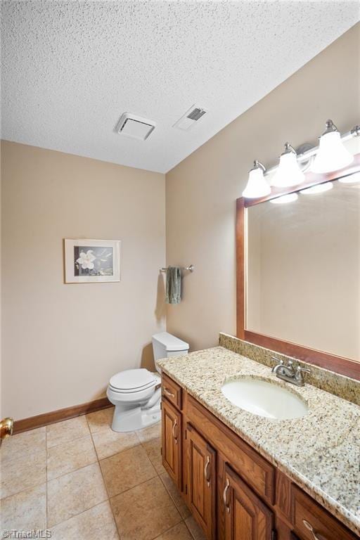 bathroom featuring vanity, tile patterned flooring, a textured ceiling, and toilet