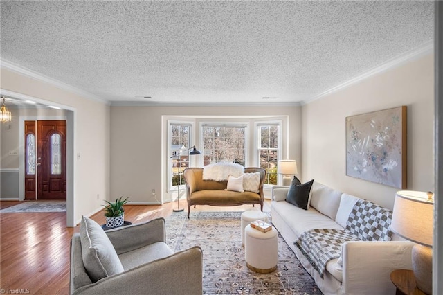 living room with ornamental molding, hardwood / wood-style floors, a notable chandelier, and a textured ceiling