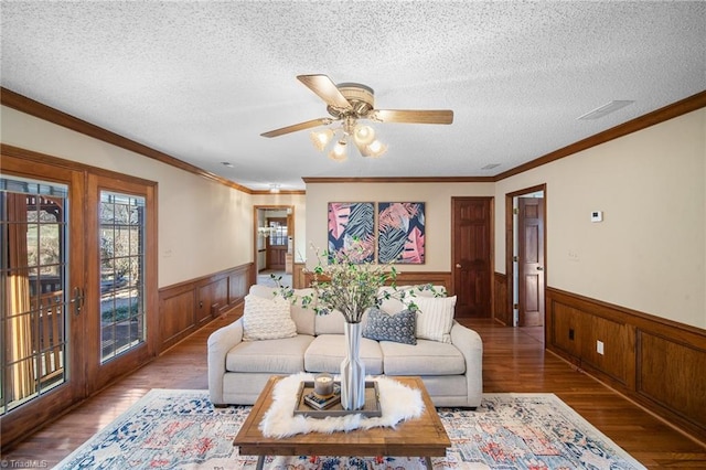 living room with crown molding, ceiling fan, hardwood / wood-style flooring, and a textured ceiling