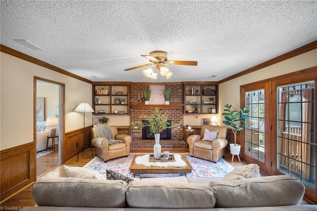 living room with crown molding, a textured ceiling, and light hardwood / wood-style flooring