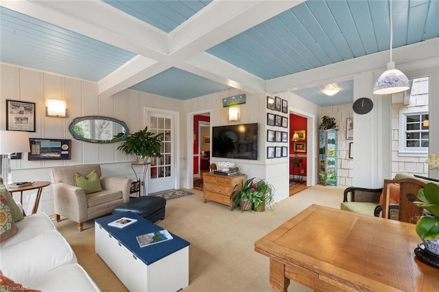 carpeted living area featuring beamed ceiling