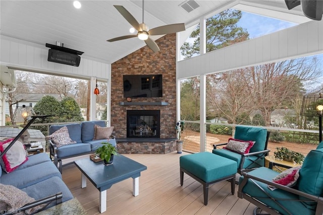 exterior space featuring visible vents, plenty of natural light, an outdoor stone fireplace, and wood finished floors