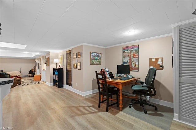 office space with baseboards, light wood-style floors, and crown molding