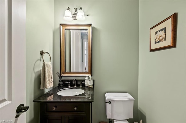 half bathroom featuring vanity and toilet