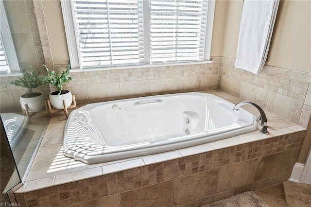 bathroom featuring a healthy amount of sunlight and a jetted tub