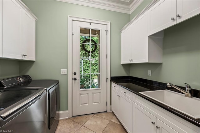 clothes washing area with cabinet space, a sink, ornamental molding, light tile patterned flooring, and washer and dryer
