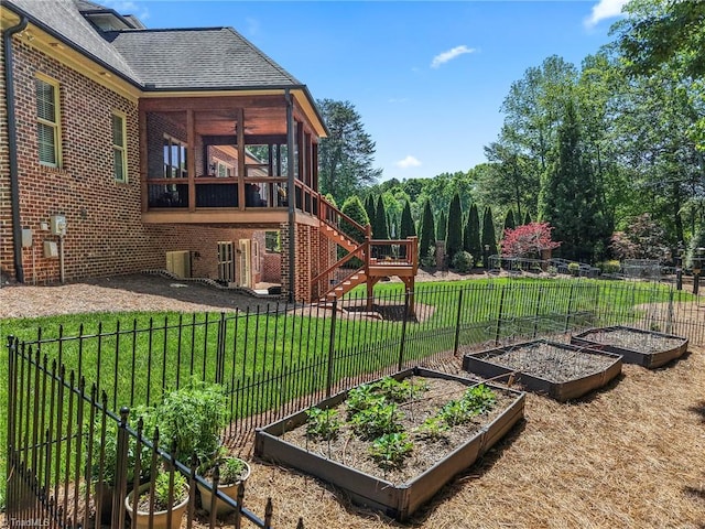 view of yard with fence, a garden, and a sunroom