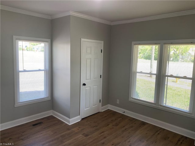 interior space with baseboards, visible vents, crown molding, and dark wood-style floors