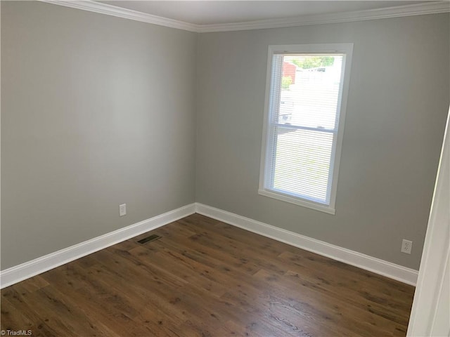 empty room with baseboards, ornamental molding, visible vents, and dark wood-style floors