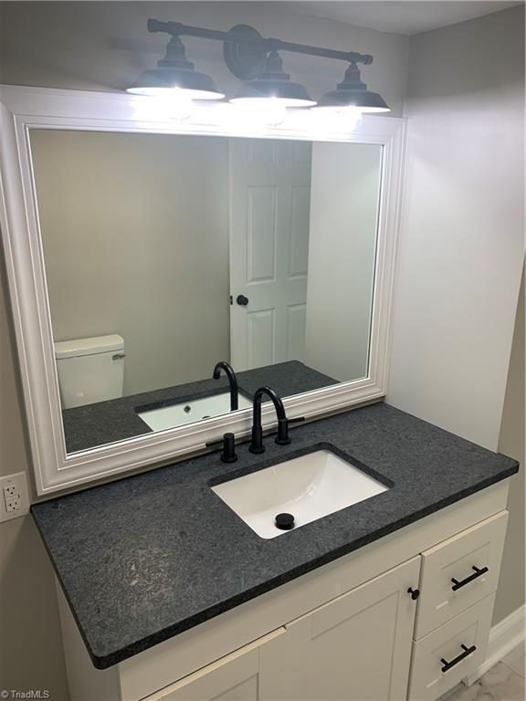 bathroom with baseboards, vanity, and marble finish floor