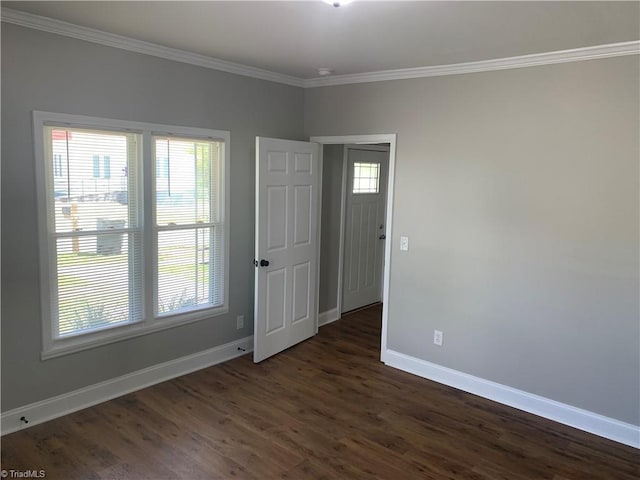 unfurnished room featuring baseboards, ornamental molding, and dark wood finished floors