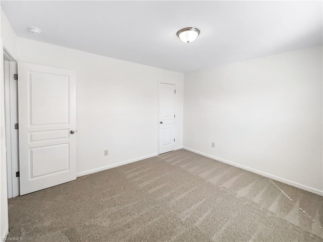 unfurnished room with baseboards and carpet floors