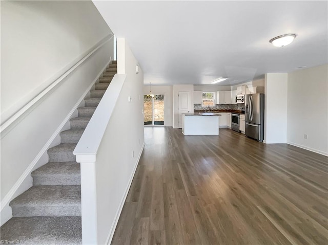 interior space featuring dark wood finished floors, stairs, and baseboards