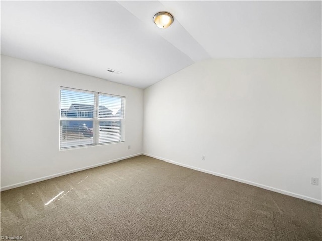 unfurnished room with visible vents, carpet floors, baseboards, and vaulted ceiling