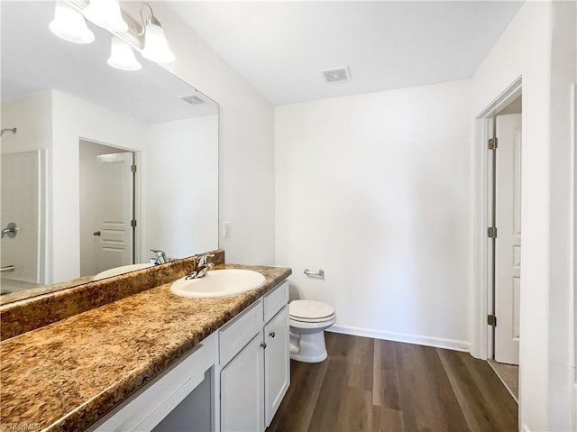 full bath with visible vents, toilet, wood finished floors, a shower, and vanity