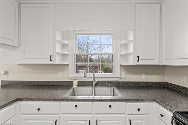 kitchen featuring sink, white cabinetry, and electric stove