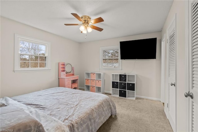 carpeted bedroom featuring ceiling fan and a closet