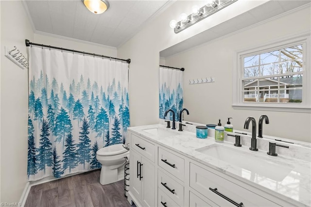 bathroom featuring wood-type flooring, toilet, vanity, and crown molding