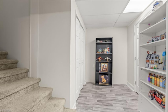 staircase with a drop ceiling and hardwood / wood-style floors