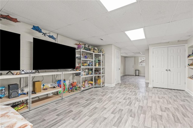 game room featuring light hardwood / wood-style flooring and a paneled ceiling