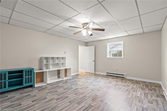 interior space featuring ceiling fan, a paneled ceiling, baseboard heating, and wood-type flooring