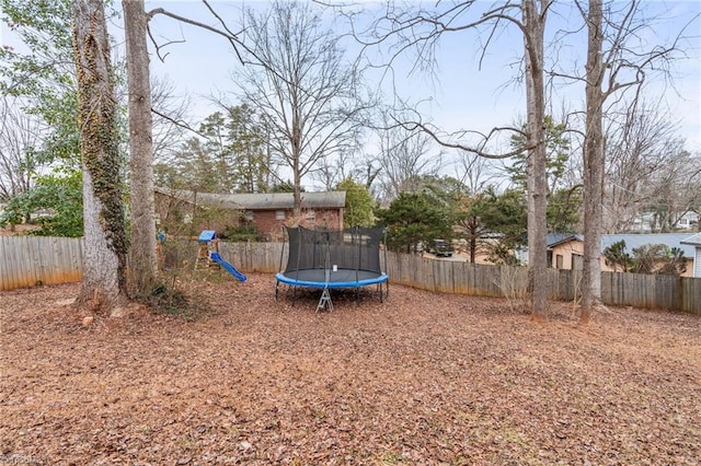 view of yard with a playground and a trampoline