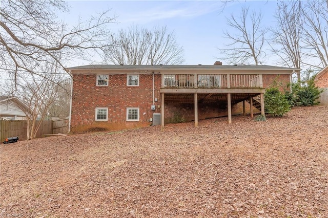 rear view of property featuring central AC unit and a wooden deck