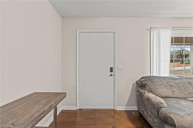 entryway with a textured ceiling and dark hardwood / wood-style floors