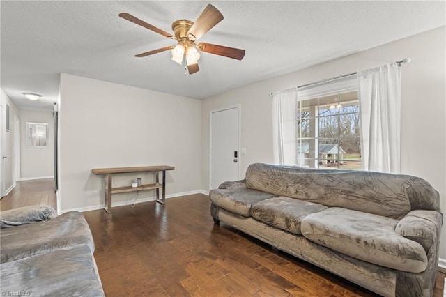 living room featuring ceiling fan and dark hardwood / wood-style flooring