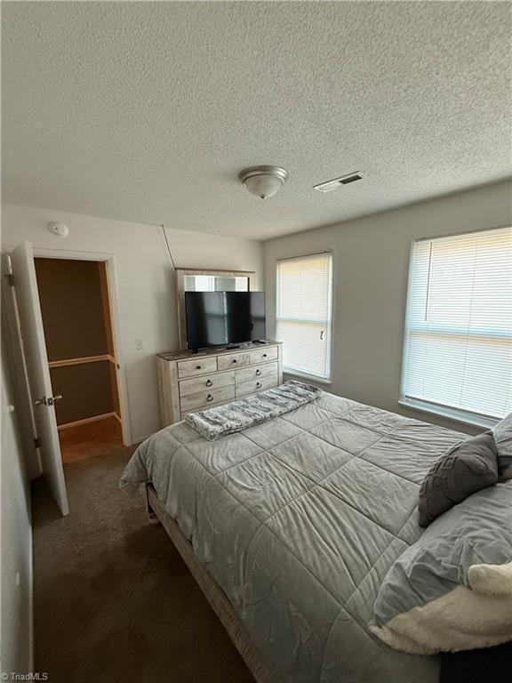 bedroom with carpet and a textured ceiling