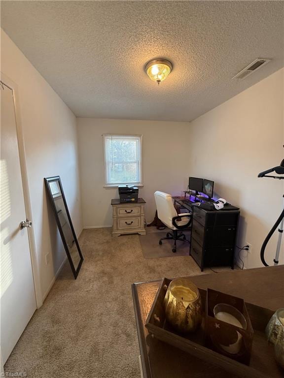 office space with light carpet and a textured ceiling