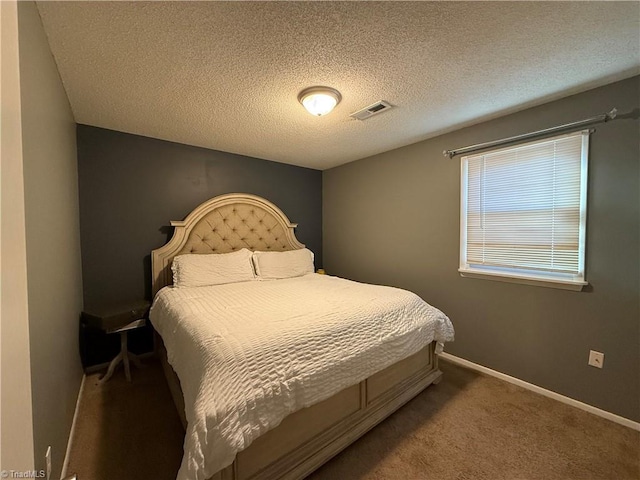 bedroom featuring carpet flooring and a textured ceiling