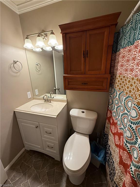 bathroom with vanity, ornamental molding, and toilet