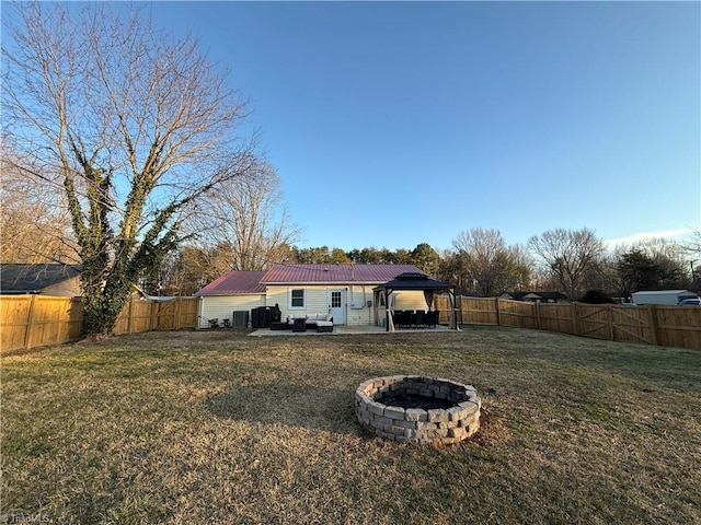 rear view of house featuring a fire pit, a lawn, a patio area, and a gazebo