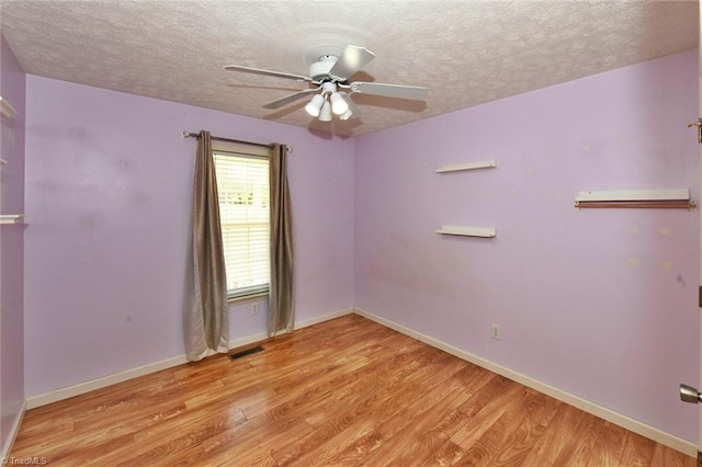 spare room featuring visible vents, baseboards, a ceiling fan, and light wood finished floors