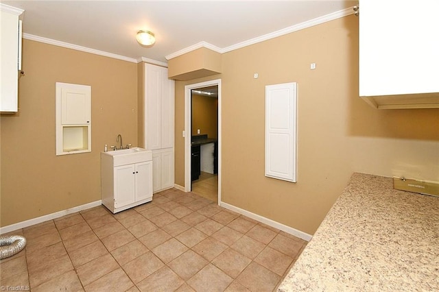 kitchen with baseboards, white cabinetry, ornamental molding, and light countertops